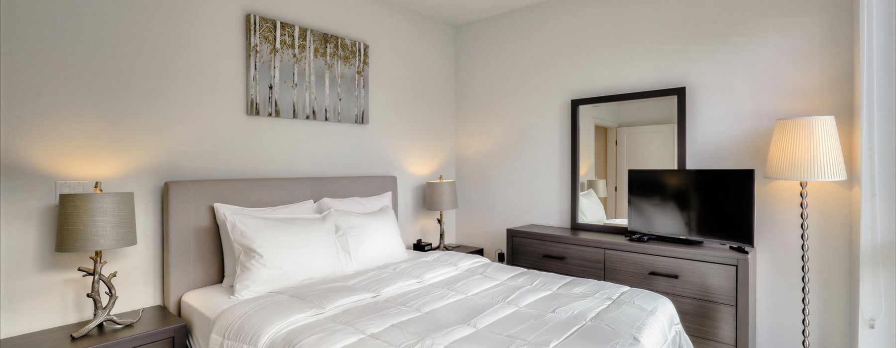 a bedroom with a bed and lamps